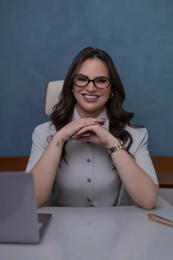 Dra. Hanna Beatriz sentada à mesa do consultório